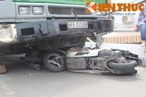 Chiếc xe rác tiếp tục lao qua bên kia đường rồi máng vào hông chiếc xe tải rồi cuốn 4 chiếc xe máy vào gầm, kéo lê một đoạn mới chịu dừng lại.
