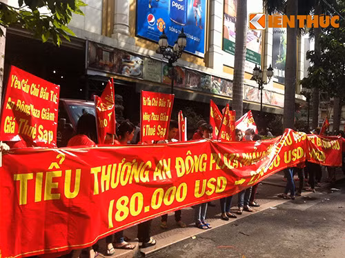 Hàng trăm tiểu thương tập trung trước mặt tiền trung tâm, trên tay cầm băng rôn với nội dung phản đối quy định tăng giá cho thuê.