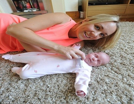 Bà mẹ trẻ bên cô con gái bé nhỏ vừa chào đời.