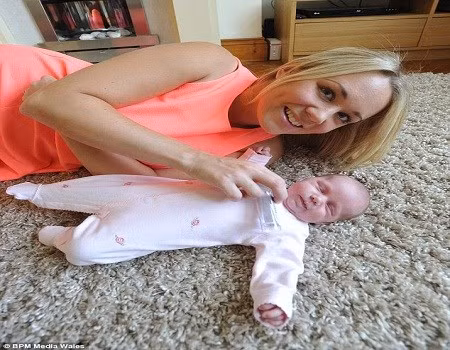 Bà mẹ trẻ bên cô con gái bé nhỏ vừa chào đời.