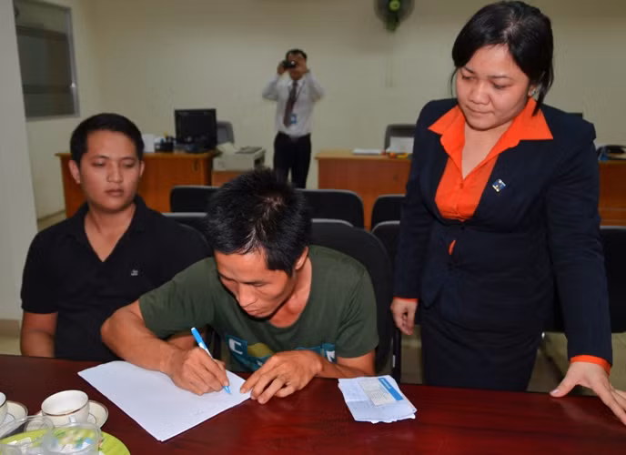 Anh Hậu được nhân viên ngân hàng hướng dẫn thủ tục để hoàn trả lại tiền đã nhận qua tài khoản