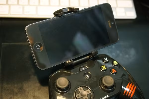  3. Mad Catz C.T.R.L.i Mobile Gamepad. Mad Catz C.T.R.L.i Mobile Gamepad là phụ kiện tuyệt vời dành cho những người mê chơi game khi hứa hẹn mang đến một trải nghiệm giải trí đích thực. Người dùng thậm chí còn có thể trải nghiệm các trò chơi đồng độ trên iPhone cùng Mad Catz C.T.R.L.i Mobile Gamepad khi mỗi thiết bị có thể tiếp nhận cùng lúc tới 4 tay cầm thông qua kết nối Bluetooth. Mad Catz C.T.R.L.i Mobile Gamepad sử dụng pin AAA và có thể đáp ứng được khoảng 40 giờ chơi game liên tục trước khi người dùng cần thay pin mới. 