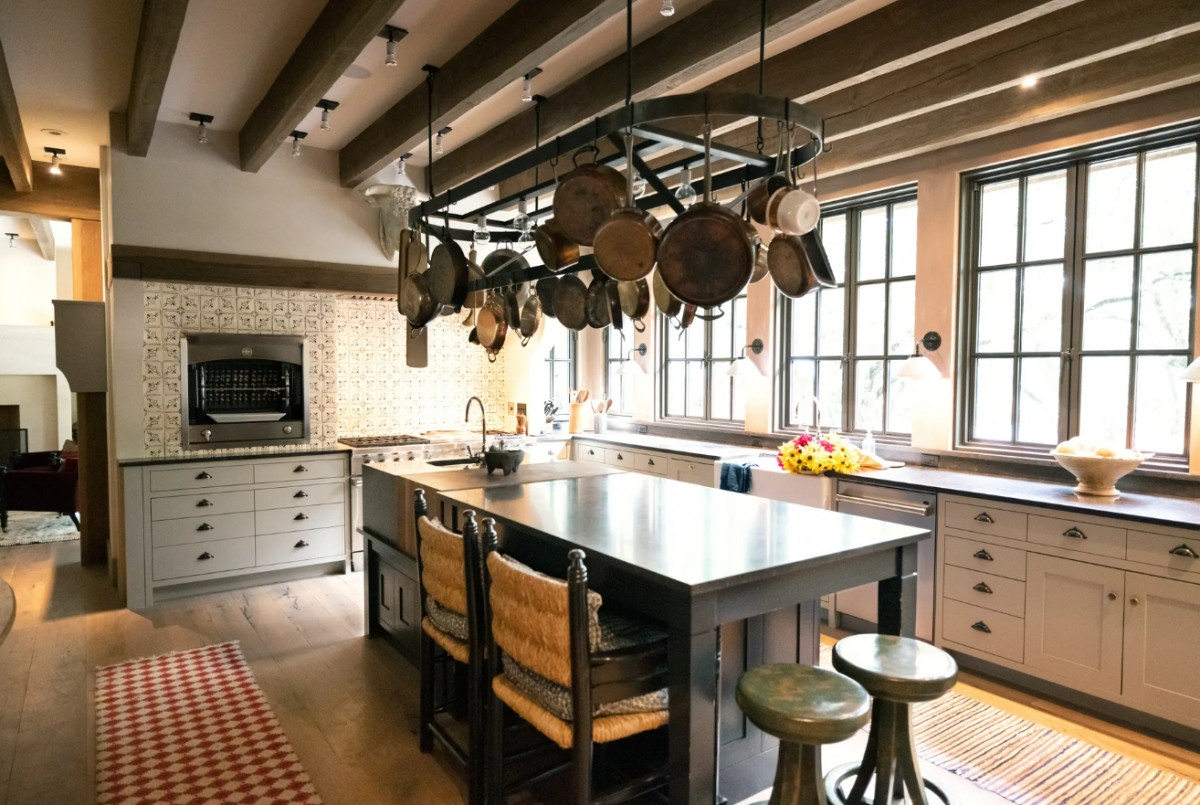  Phòng bếp được thiết kế theo phong cách đồng quê những bức tường màu trắng sữa. Thay vì sử dụng bàn đá cẩm thạch, căn phòng được trang trí với chất liệu gỗ, tạo cảm giác gần gũi với thiên nhiên. Căn phòng cũng bao gồm giá treo chảo, xoong, nồi trên trần nhà để giữ lại nét cổ điển vốn có.