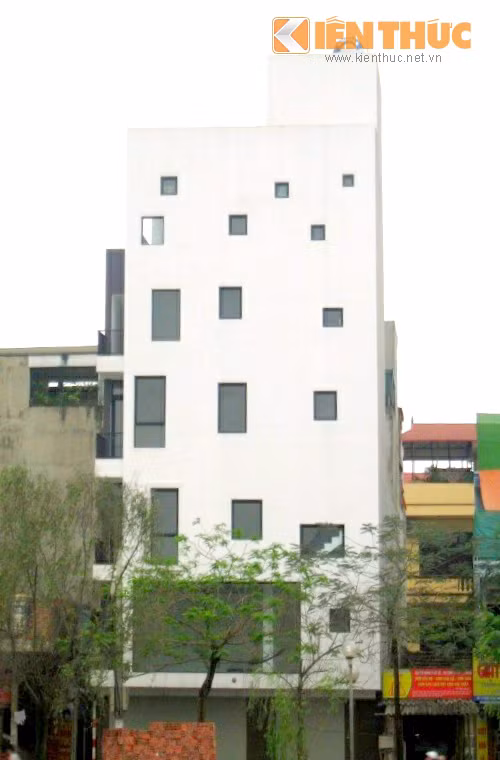 Với mục đích tạo vẻ bắt mắt, thu hút người đến thuê căn hộ và văn phòng làm việc, chủ nhà trên phố Định Công Thượng (Hoàng Mai) đã chọn thiết kế khá "độc", khung cửa kính được sắp xếp hài hòa tỉ lệ, màu tối tương phản với sơn tường trắng, tạo sự sinh động cho mảng tường mặt trước của nhà.