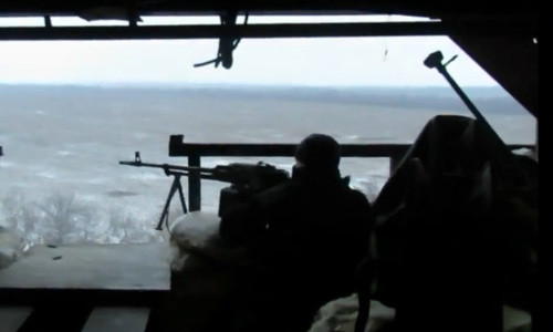 Binh sĩ ly khai bắn súng máy PK, đăng sau anh ta là đầu nòng khẩu PTRD.