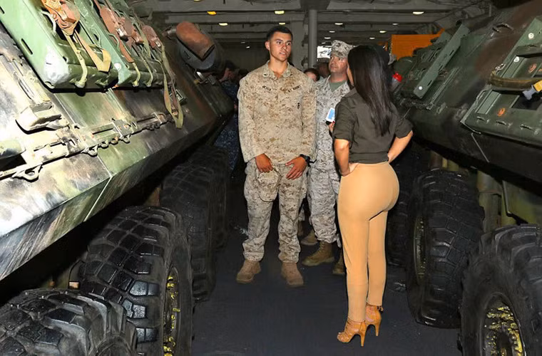 Trong ảnh, mẫu Kim siêu vòng 3 đứng nói chuyện với binh sĩ Mỹ giữa lối đi nhỏ trong khoang chở phương tiện chiến đấu của hải quân.
