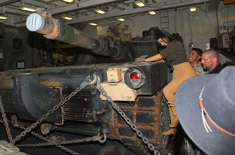 Các sĩ quan Mỹ đang giúp cô Kim leo lên chiếc xe tăng chiến đấu chủ lực khổng lồ M1 Abrams.