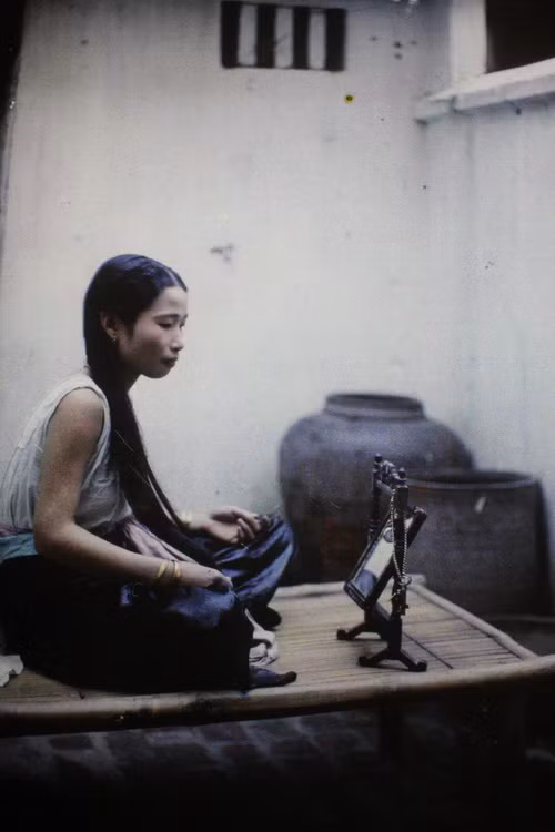 Thiếu nữ ngồi trước gương.