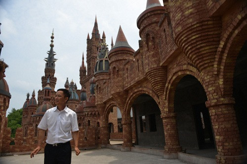 Liu Chonghua đứng trước một tòa lâu đài của mình.