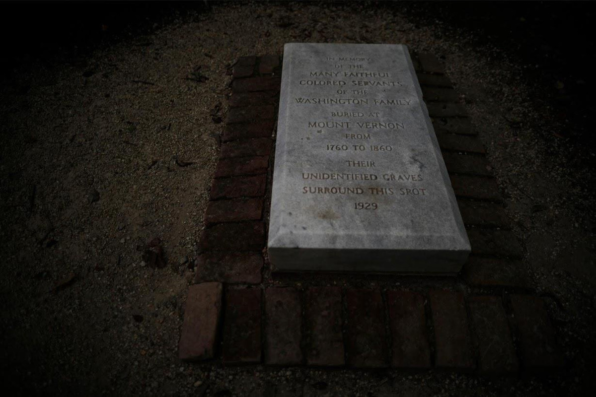 Một tấm bia tại khu di tích Mout Vernon với dòng chữ "Tưởng nhớ những người hầu hạ trung thành của gia đình Washington, chôn tại núi Vernon từ năm 1760 đến 1860. Những ngôi mộ không tên của họ nằm xung quanh vị trí này". Ảnh: Reuters.