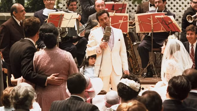 br/> Vùng Sicily có một truyền thống đặc biệt. Theo đó, Vito Corleone không thể từ chối các lời thỉnh cầu của người khác trong đám cưới con gái mình. Johnny Fontane, một người con nuôi khác của Vito, cũng đang cần sự hỗ trợ của cha đỡ đầu. Sự nghiệp của Johnny hiện không mấy sáng sủa mà anh ta cần sự hỗ trợ của nhà Corleone cho vai diễn sắp tới. Ảnh: Notinhalloffame.