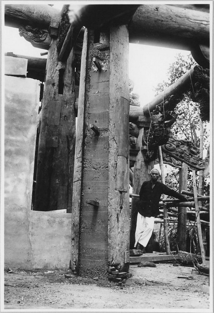 Một khu vực đang được trùng tu, với cây cột gỗ được gia cố bằng bê-tông.