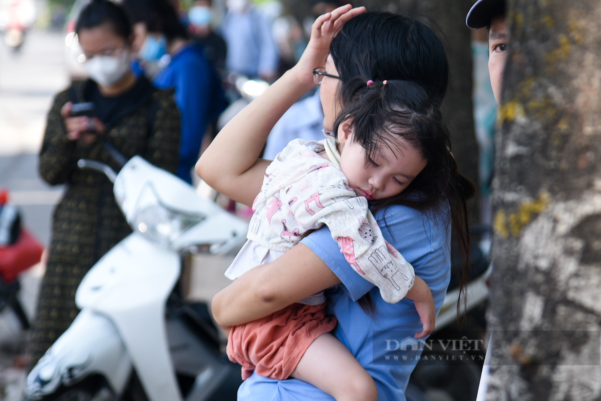 Nhiều trẻ nhỏ vì đợi quá lâu nên mệt mỏi và ngủ thiếp đi trên tay mẹ.