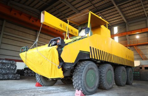 Chiếc xe chiến đấu bộ binh trở thành một chiếc xe cần cẩu dân sự nhờ sử dụng kết hợp các tấm gỗ và vải sơn màu vàng.