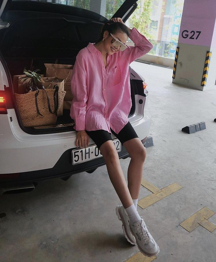 Thanh Hằng đi siêu thị mùa dịch với set đồ cá tính, chất chơi khi phối quần xe đạp cùng sơ mi phom rộng sắc hồng nổi bật, đi kèm sneaker hầm hố vô cùng nổi bật. Cô còn khéo léo chọn đôi kính mắt nổi bật cá tính.