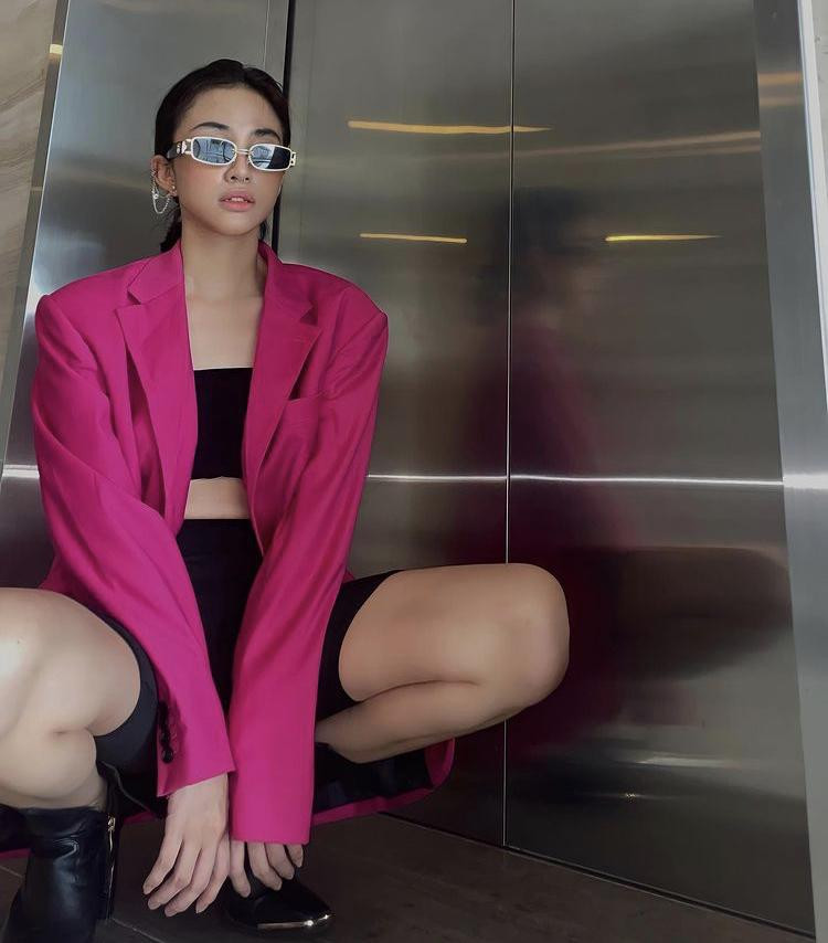 Người mẫu Thiên Nga ra hành lang chụp ảnh với mốt quần xe đạp mix kèm áo quây, blazer, boots cao cổ và mắt kính.