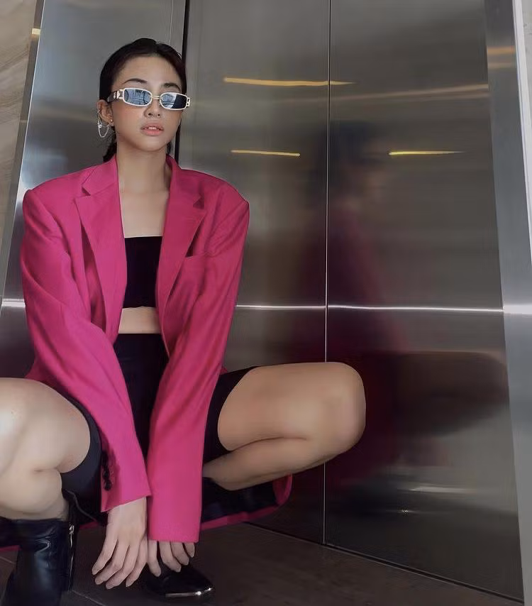 Người mẫu Thiên Nga ra hành lang chụp ảnh với mốt quần xe đạp mix kèm áo quây, blazer, boots cao cổ và mắt kính.