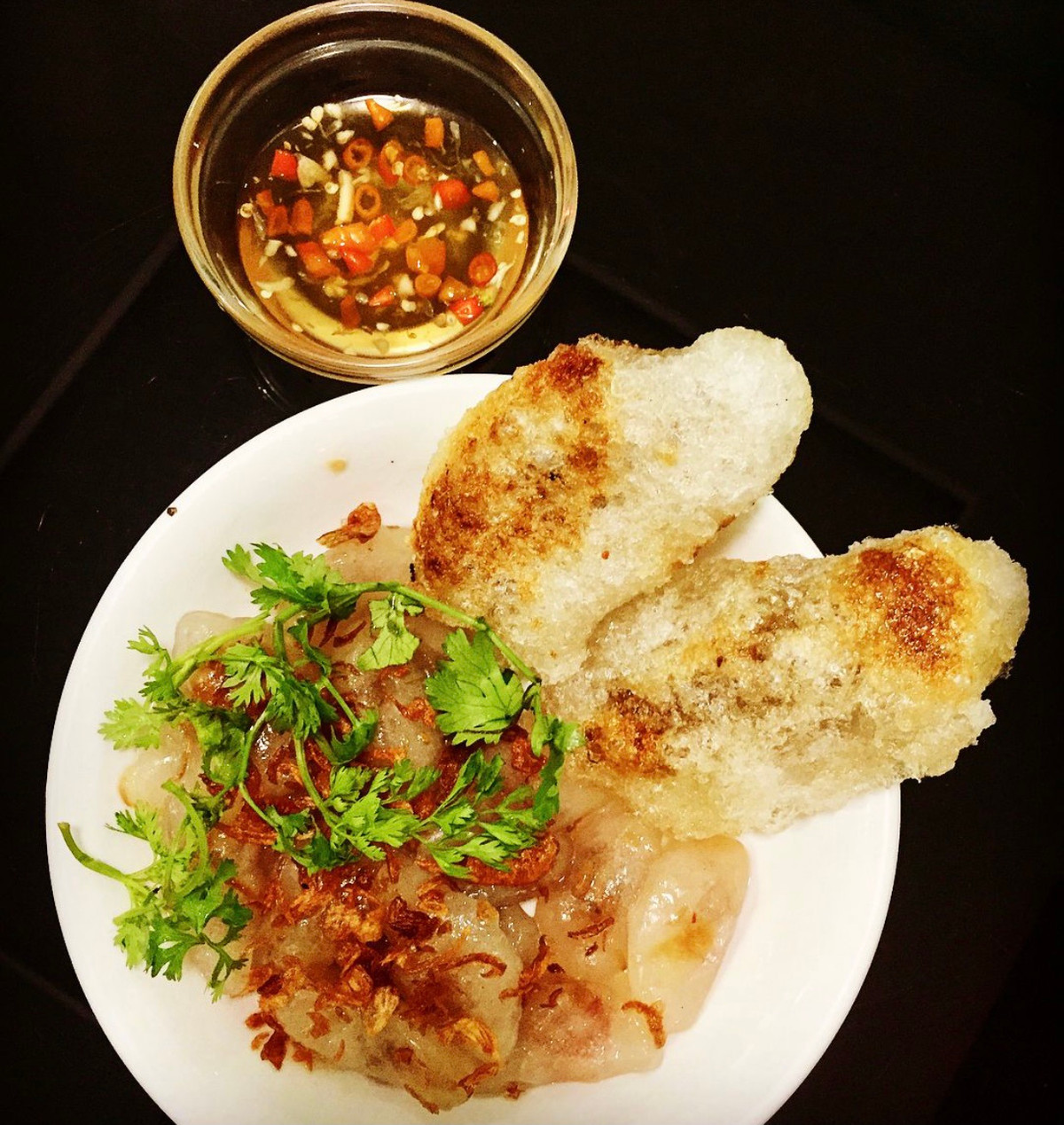 Bánh bèo Nghệ An có nhiều nét tương đồng với bánh bột lọc trần xứ Huế. Bánh được làm từ bột lọc, cho nhân vào rồi vắt thành hình tròn dẹt, gập đôi lại. Khi chín, vỏ bánh trong để lộ nhân tôm và thịt nạc bên trong. Người thưởng thức thêm hành khô và rưới nước mắm. Ảnh: Thu_hien0109.