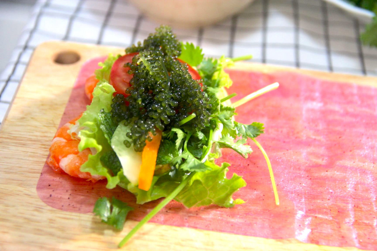  Gỏi cuốn tôm rong nho là gợi ý ẩm thực lạ miệng cho gia đình bạn trong những ngày giãn cách. Thành phần gồm tôm bóc vỏ chiên bơ, rong nho. Ngoài ra, các loại rau củ quả như cà rốt, dưa chuột thái sợi, cà chua xắt lát mỏng, rau mùi, lá bạc hà, rau thơm, xà lách... giúp tăng sự thanh mát. Để món ăn trở nên khác biệt, người chế biến có thể sử dụng bánh tráng thanh long để cuốn. Bạn thưởng thức gỏi cuốn chấm nước mắm tỏi ớt. Ảnh: Tạ Nhương.