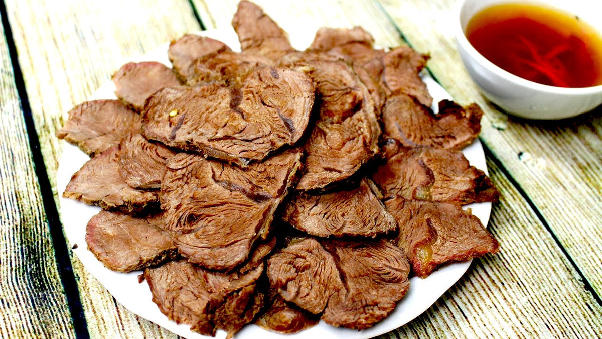 Bắp bò kho mật mía là món ăn hấp dẫn ở xứ Nghệ. Người ta sơ chế bắp bò chắc thịt với nước chè xanh, đem ủ với nhiều gia vị như gừng, hành, tỏi, sả, ớt, hồi, quế... và nhất là hỗn hợp mật mía cùng nước mắm. Trong đó, mật mía xứ Nghệ chính là thành phần không thể thiếu, tạo nên nét đặc trưng của món ăn. Thịt bắp được ủ lâu với gia vị sẽ càng thơm ngon. Sau đó, bắp bò được kho đến khi rút lại, đủ để gia vị và mắm, mật thấm vào trong. Khi ăn, bắp bò được thái lát mỏng. Ảnh: Nhung Cooking.