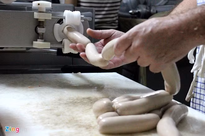 Những dây xúc xích dài vừa được máy "nhả" ra. Vỏ xúc xích được làm từ ruột heo, không phải loại collagen như các loại xúc xích công nghiệp.