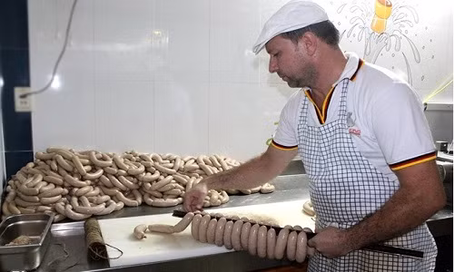 Ông Klaus Rutt cẩn thận xếp từng dây xúc xích để cho vào lò xông khói. Chúng phải trải qua nhiều chế độ khác nhau trong lò. Sức chứa của một lò ở đây hơn 1.000 cây, và phải mất 2h 30 phút để ra một mẻ xúc xích mới.