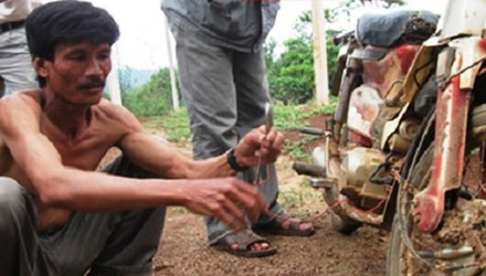 Anh Khải cầm bugi xe máy khi xe đang nổ.