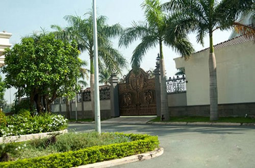 Bên ngoài ngôi biệt thự được trang trí bởi khá nhiều cây xanh và đặc biệt là cánh cửa sắt chạm khắc cầu kỳ. Phía trước cổng còn có cả bốt canh dành riêng cho bảo vệ dù cửa ra vào được lắp thiết bị tự động rất hiện đại.