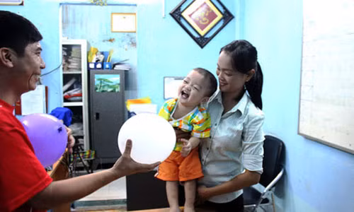 Bé trai vui đùa với cán bộ phường. (Ảnh: Hải Hiếu)