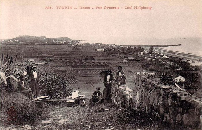 Những người phụ nữ khiêng ghế kiệu nghỉ ngơi gần một đồng lúa.