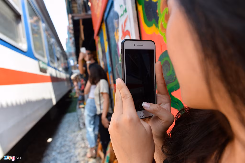 Diệu Linh, sinh viên Đại học Công nghiệp Hà Nội, lần đầu đến đây. Chị khá sợ khi đứng đúng khúc cua vì tàu chỉ cách người khoảng 30 cm.