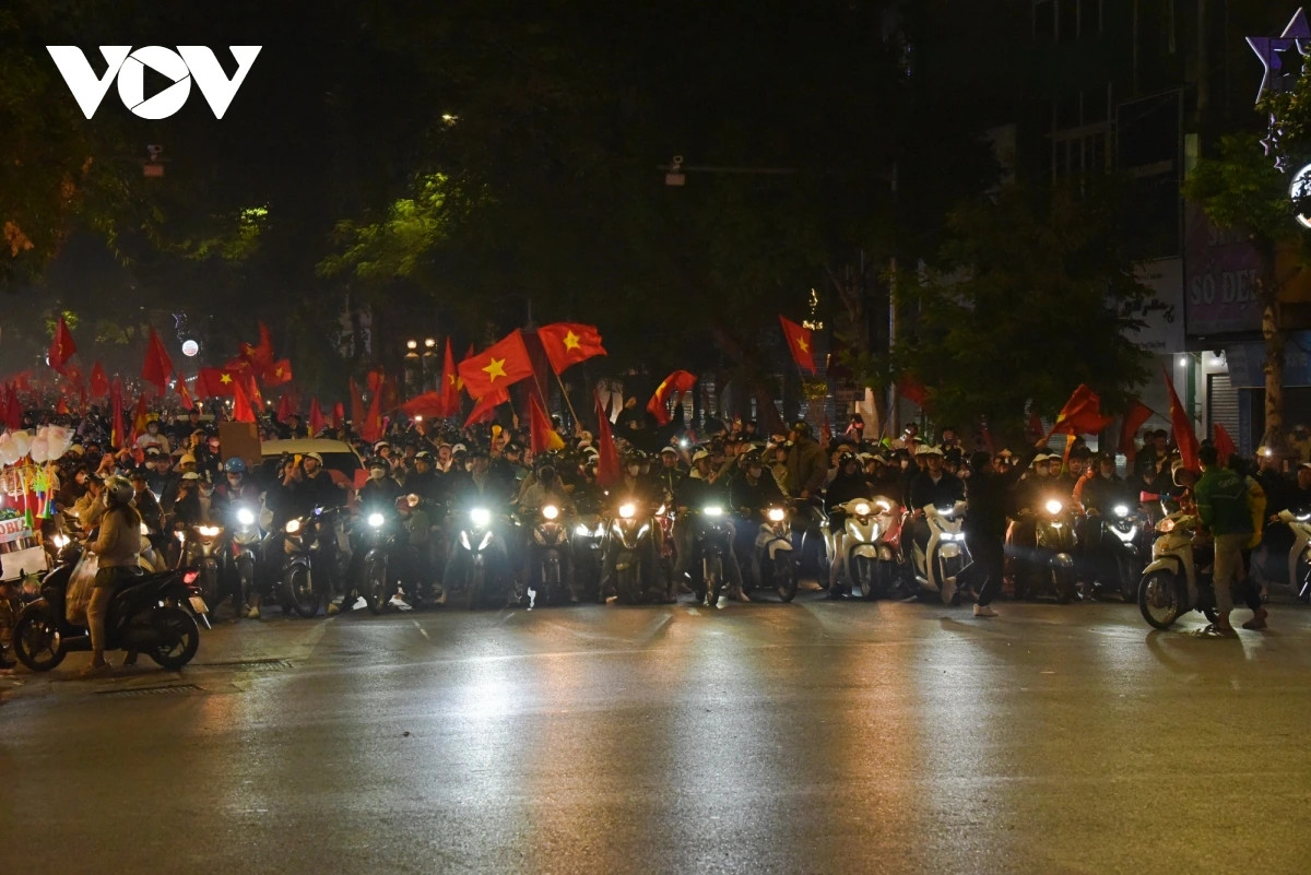 Ăn mừng niềm vui chiến thắng nhưng người dân không quên chấp hành dừng đèn đỏ trong khi tham gia giao thông.