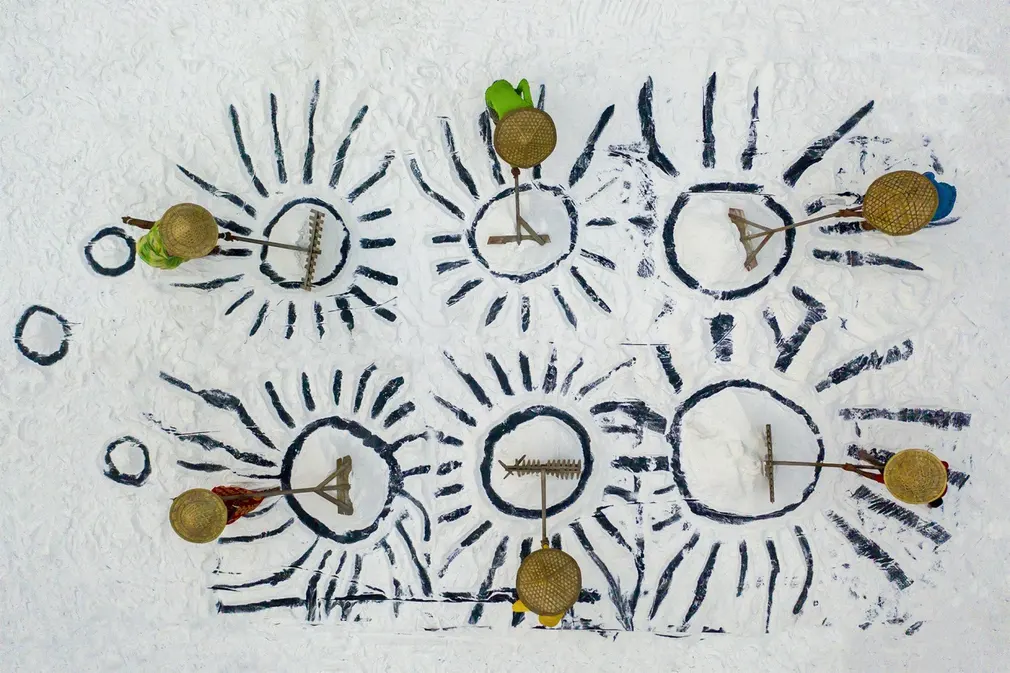 Trong một đụn muối, 2 người phụ nữ và 4 người đàn ông tạo ra các họa tiết.