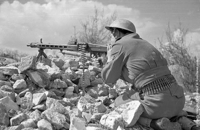 Một người lính trong tư thế sẵn sàng chiến đấu với khẩu súng máy.