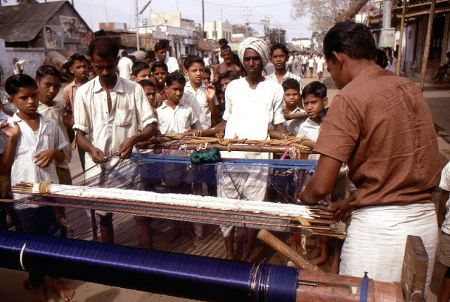 Những người thợ dệt làm việc với khung cửi thủ công trên đường phố Madurai.
