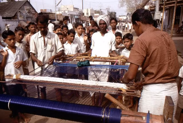 Những người thợ dệt làm việc với khung cửi thủ công trên đường phố Madurai.