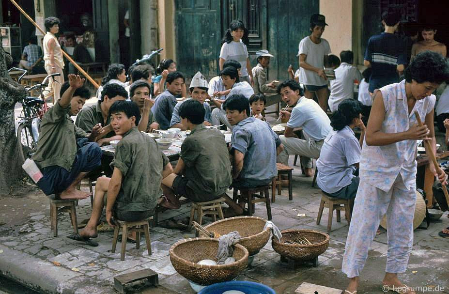 Một quán nhậu ở Hà Nội năm 1991. “Nơi đây có món máu lợn tươi ăn với ruột cắt nhỏ, rau thơm và đậu phộng dành cho bữa sáng”, nhiếp ảnh gia Hans-Peter Grumpe cho hay. Ảnh: Hans-Peter Grumpe / Hpgrumpe.de.