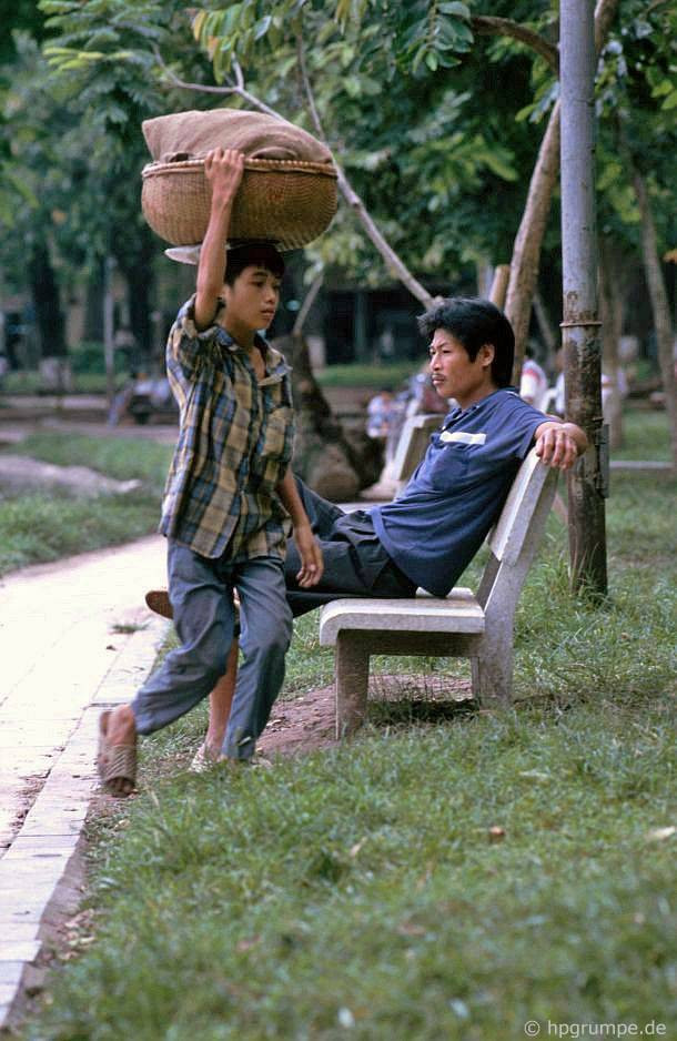 Cậu bé này đội thúng bánh mì đi vòng quanh bờ hồ để tìm kiếm thực khách, 1992.