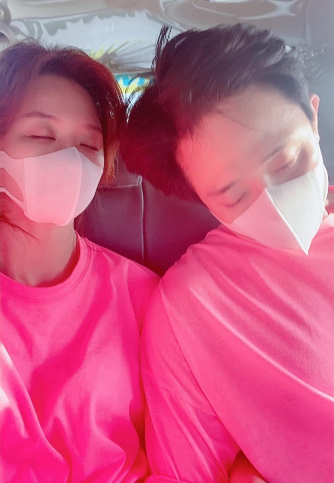 Vợ chồng Trấn Thành - Hari Won tông xuyệt tông với trang phục hồng khi ngồi trên xe ô tô. Cả 2 thấm mệt sau một ngày dài với lịch làm việc dày đặc.