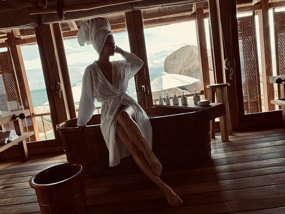 Phòng tắm view ra biển cũng là địa điểm "sống ảo" yêu thích của Jennifer Phạm. Cô mặc áo choàng tắm hờ hững tạo dáng trước ống kính của chồng.