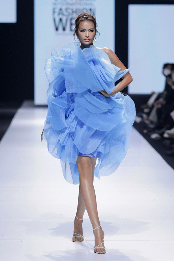 Hoa hậu siêu quốc gia châu Á - Ngọc Châu mở màn ấn tượng với bộ cánh tạo phom kỳ công bồng bềnh. Gam màu xanh bluesky hợp mốt đồng thời mở đầu cho những bộ cánh tiếp theo mang đậm hơi thở của thời trang đương đại với phong cách deconstruction.
