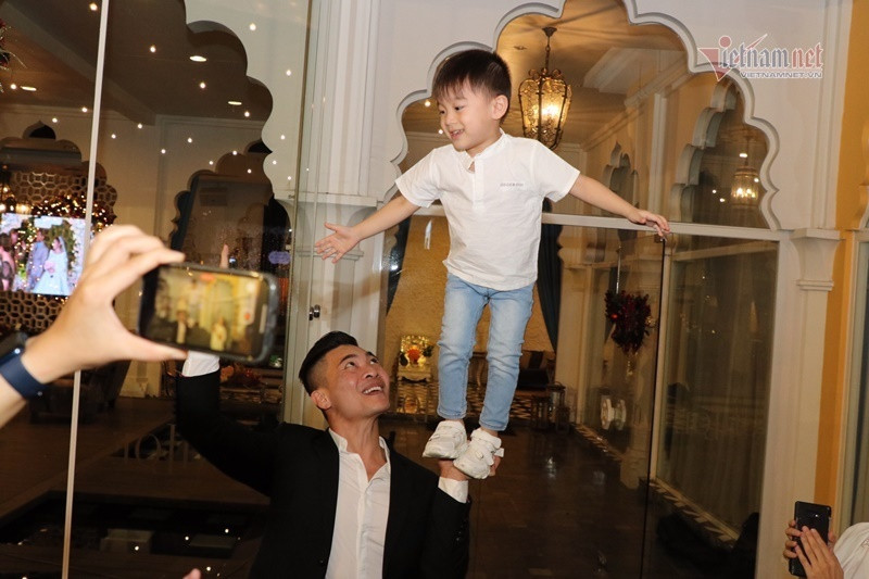Vợ chồng Quốc Cơ - Hồng Phượng đưa con trai đầu lòng dự đám cưới. Hai bố con làm xiếc trước sự chứng kiến của nhiều người.