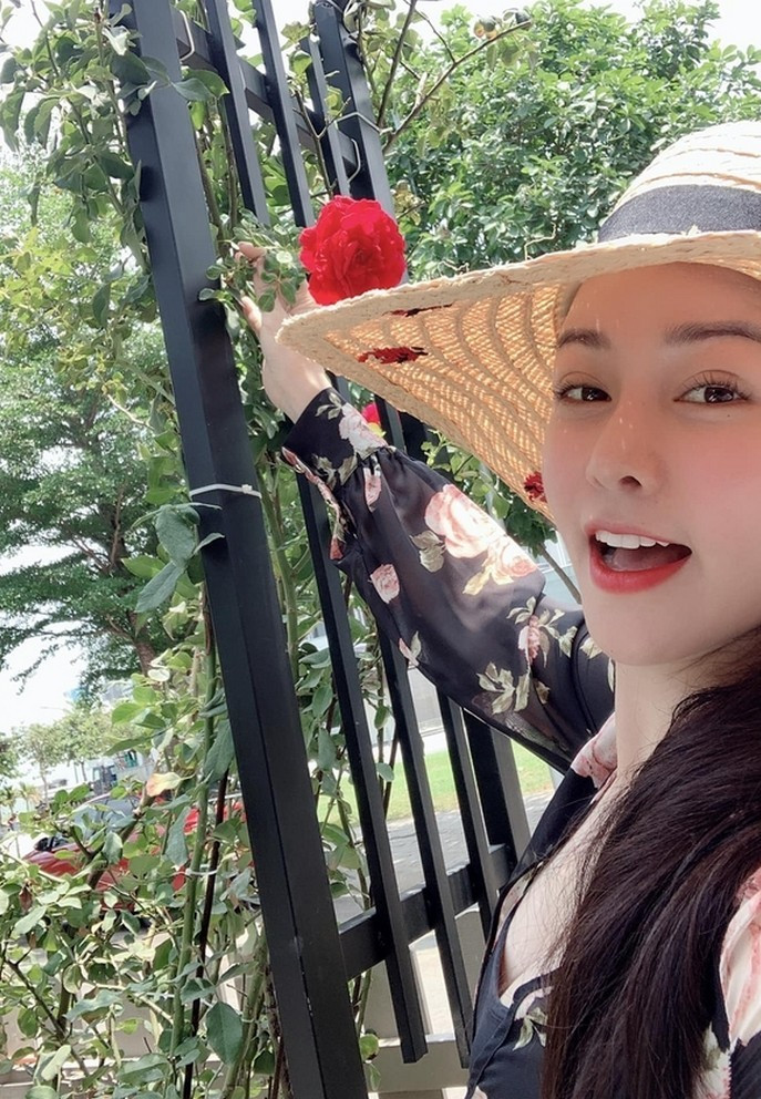 Nhật Kim Anh tự tay hái hoa hồng do mình trồng trước nhà đang nở rộ.