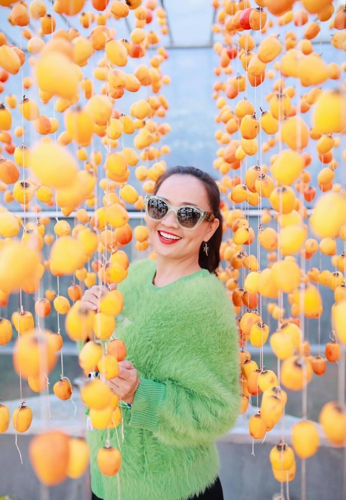 Diễn viên Hoài An thích thú khi lần đầu được ngắm và thu hoạch trái hồng treo gió - một đặc sản của Đà Lạt.