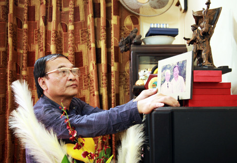 Nhà báo Trần Tuấn và bức ảnh chụp bên Đại tướng Võ Nguyên Giáp. Ảnh: Hà Thành.