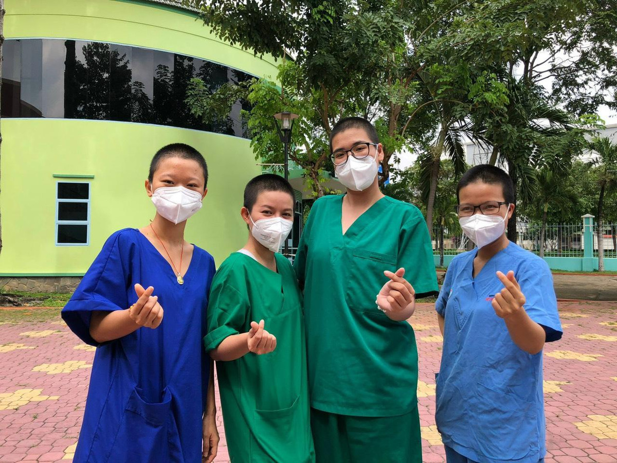 Khi tham gia tình nguyện ở Bệnh viện Hồi sức Covid-19 (TP Thủ Đức, TP.HCM) vào tháng 7, nhóm bạn gồm T rần Ngọc Bích Phương, Lê Thị Đài Trang, Nguyễn Trần Ngọc Lan, Phạm Thị Thùy Trang (tuổi từ 21 đến 26) quyết định cạo trọc đầu để tránh vướng víu khi mặc đồ bảo hộ và giảm nguy cơ lây nhiễm chéo. Họ hỗ trợ nhân viên y tế, chăm sóc F0, lau phòng bệnh, đổ rác, ai nhờ gì làm nấy. Vì an toàn của bản thân và gia đình, 4 cô gái không về nhà cho đến khi kết thúc đợt tình nguyện. Hình ảnh lạc quan của nhóm bạn khiến nhiều người cảm phục. Ảnh: NVCC.