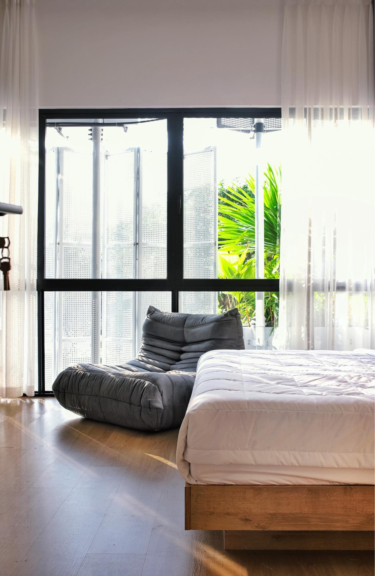 Riêng phòng ngủ ông bà, khoảng lùi được tận dụng để làm sàn thưa gỗ, thêm được không gian ngồi thư giãn nhưng vẫn làm tốt vai trò lưu thông không khí. 