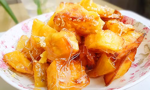 1. Khoai lang ngào đường. Đây là món ăn vặt đơn giản và khá dễ làm. Bạn chỉ cần chọn một củ khoai lang to, gọt bỏ vỏ và cắt thành từng miếng cho vừa ăn. Sau đó, luộc khoai lang chín tới và vớt ra để ráo nước. Thắng đường cho tới khi có màu cánh gián, thả khoai lang vào đảo đến khi thấy đường kéo tơ là được.