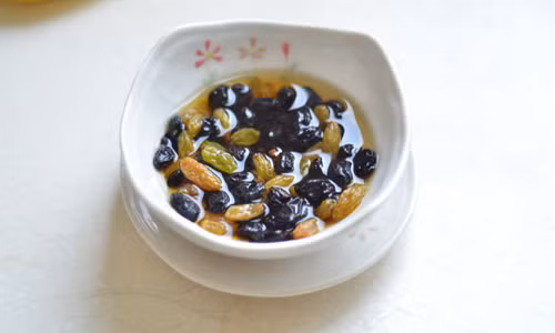 Bước 1: Đầu tiên, hãy ngâm nho khô vào rượu rum để nho ngấm rượu và nở đều.