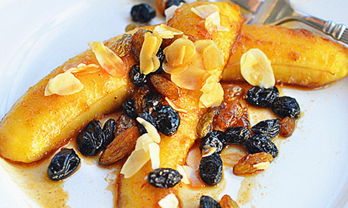 Cho chuối ra đĩa, trang trí thêm bằng hạt hạnh nhân. Vậy là bạn đã hoàn thành món chuối nướng rượu rum thơm ngon rồi.